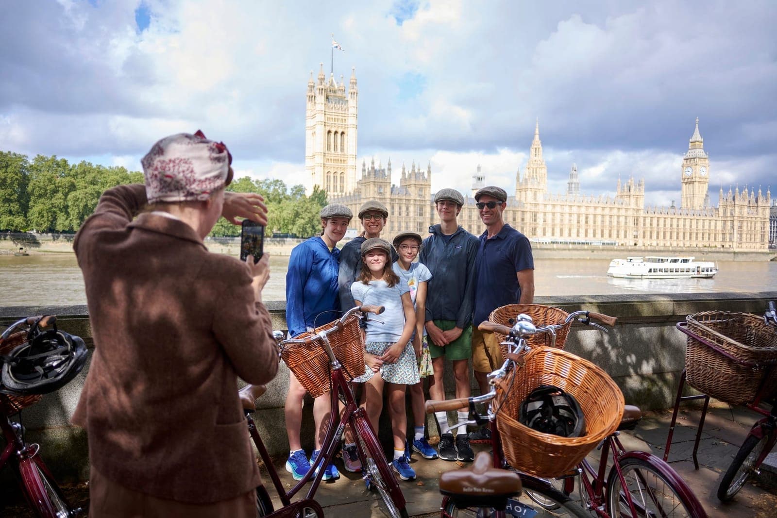 A family on a bike tour posing for photographs with Big Ben