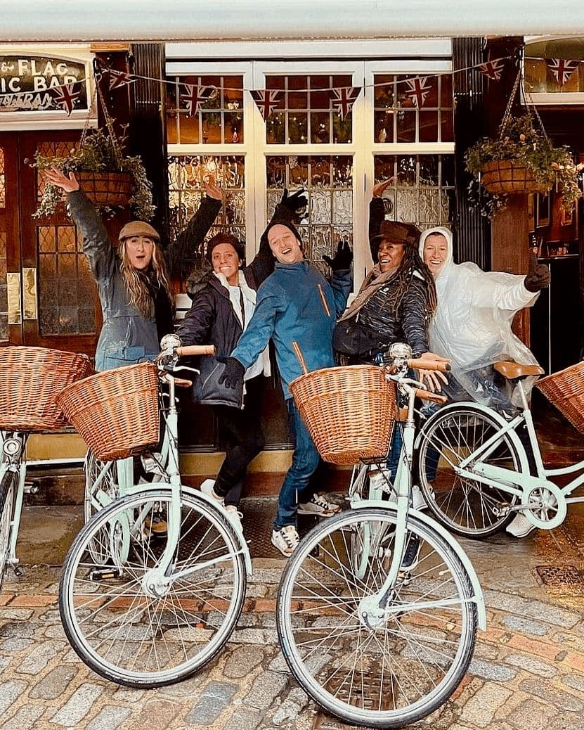 A rainy bike tour with happy smiling guests at the Lamb and Flag pub in Covent Garden