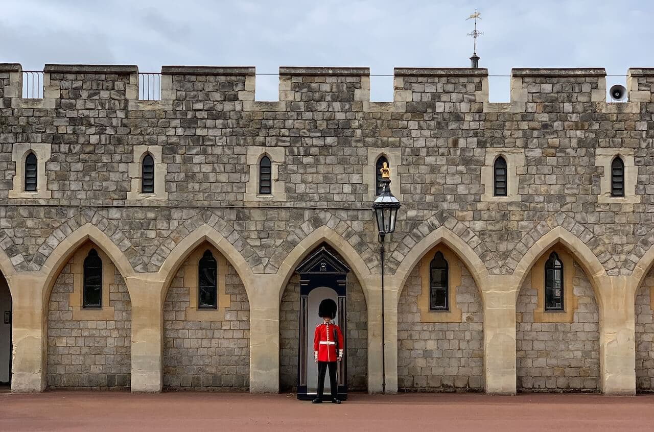 A Kings Guard in a red tunic on standing on Duty