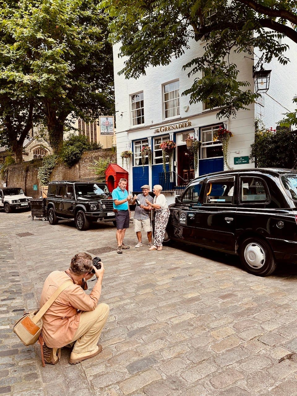 Tally Ho guests pose for their photographer outside the Grenadier Pub in London