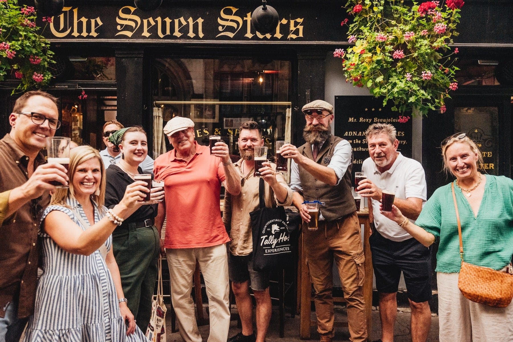 Tally Ho guests raising a glass outside The Seven Stars pub in London