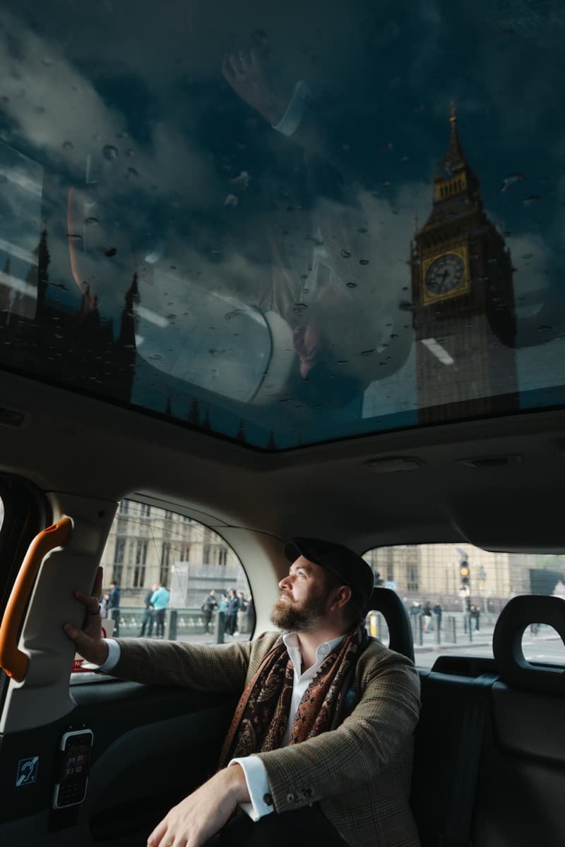 Jack Harris, founder of Tally Ho, inside a London black cab with Big Ben reflected in the panoramic roof